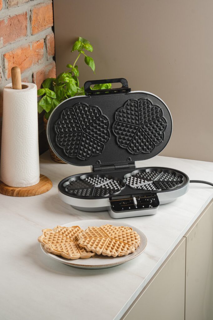 Rommelsbacher Doppel-Herzwaffeleisen mit Waffeln auf einem Teller davor